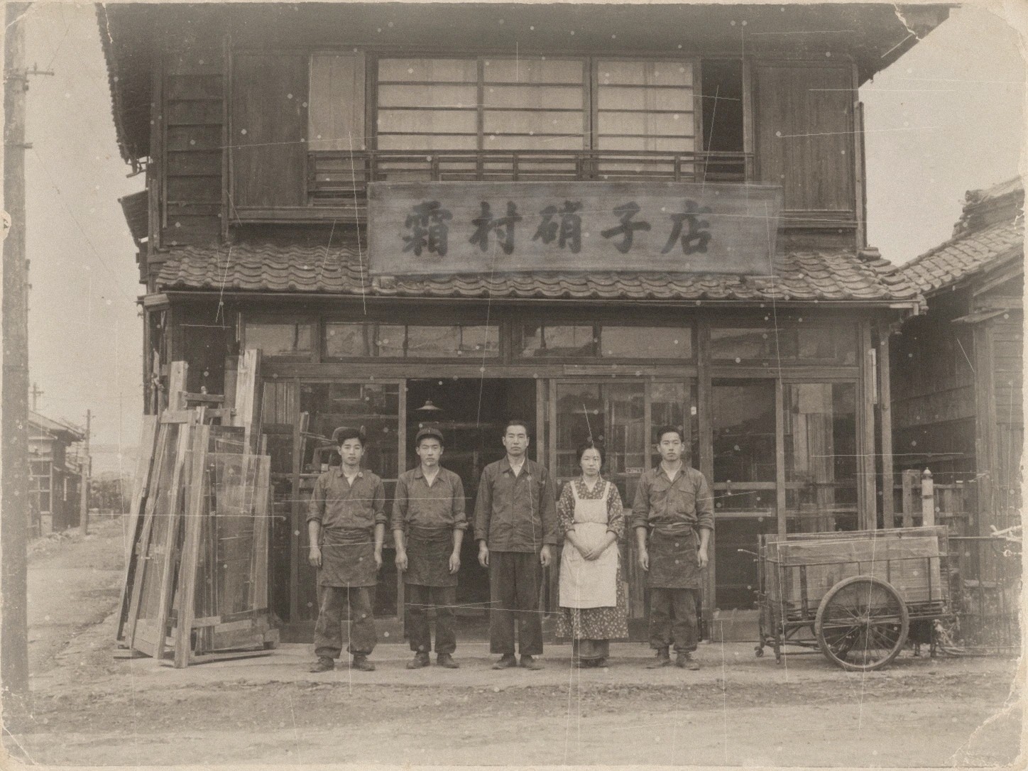 昭和30年ごろの霜村硝子店の前で、二代目 霜村 憲と家族・従業員