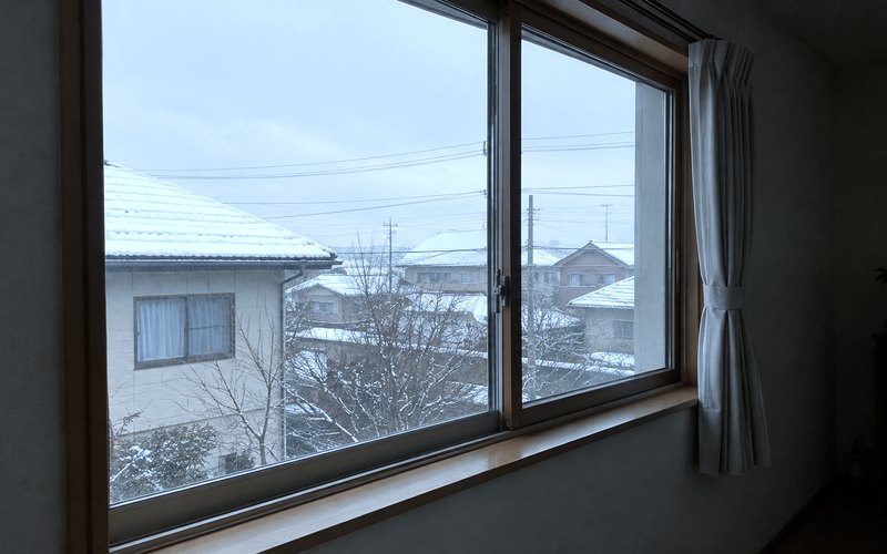 冬、窓のそばの床にひざ掛けが置かれた部屋